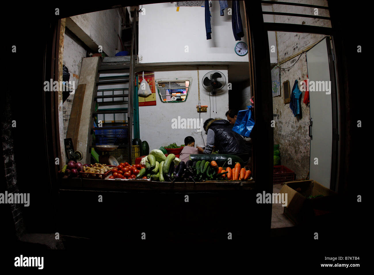 Famiglia cinese di mangiare la cena all'interno di casa come provano a aell vegitables Foto Stock