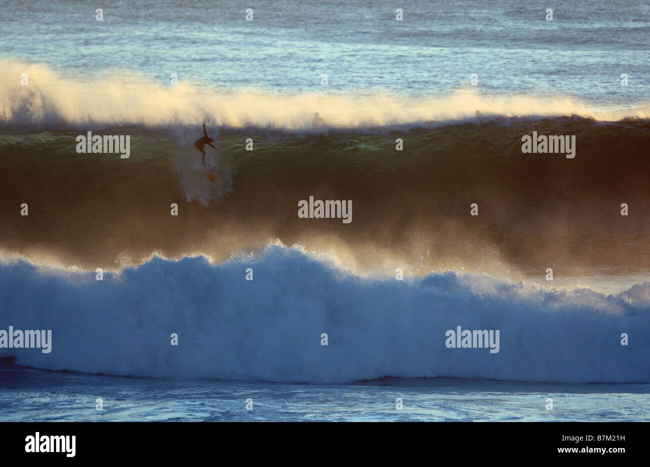 Un surfista scende giù il volto di una grande onda perfetta a Margaret River in Australia Occidentale - egli didnt rendono. Foto Stock