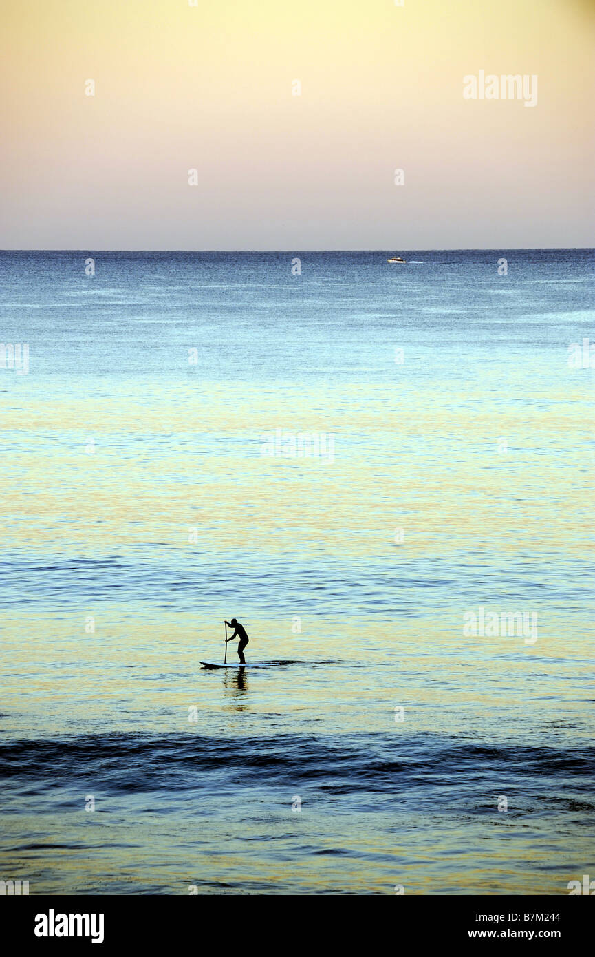 Un lone stand up paddle surfer al tramonto in Perth , Wesern Australia Foto Stock
