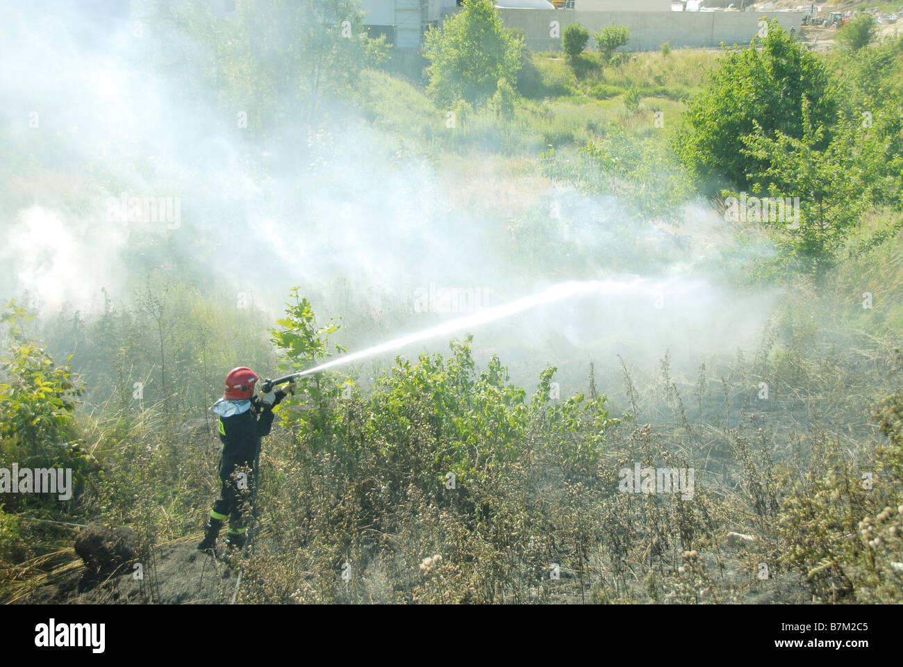 Vigili del fuoco usando un tubo flessibile a getto di aspo su un fuoco heath Foto Stock