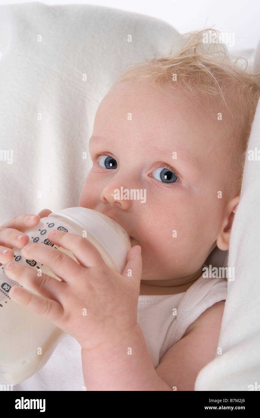 Bambino con una bottiglia di latte Foto Stock