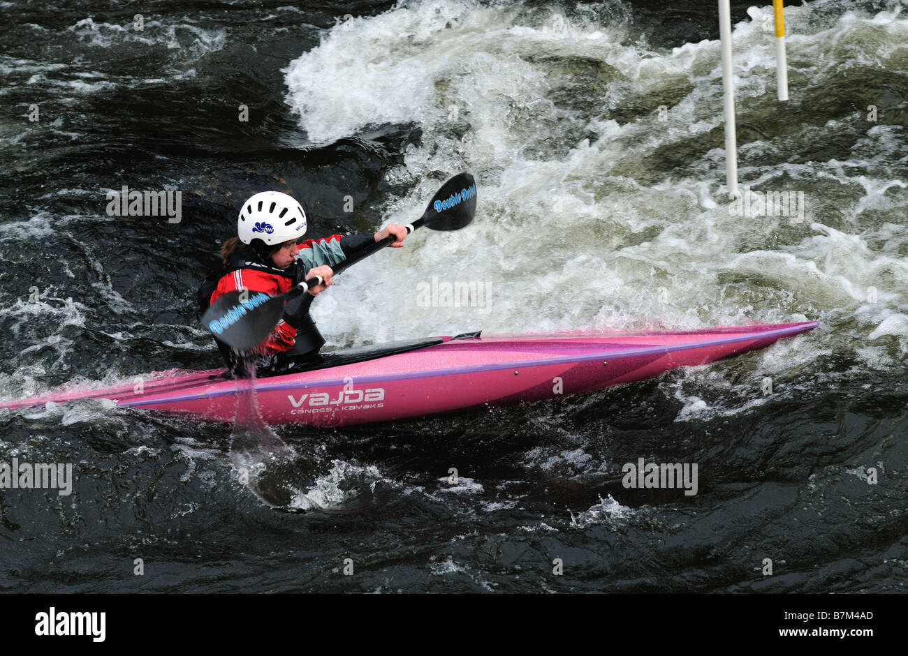 Canoeist femmina paddling in acqua turbolenta nel fiume Foto Stock