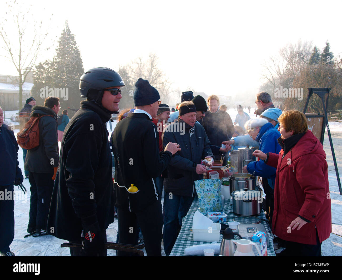 Gente che vende bevande calde e una zuppa di stanchi i pattinatori sul ghiaccio durante il mulino a vento molentocht tour Oud Alblas nei Paesi Bassi Foto Stock