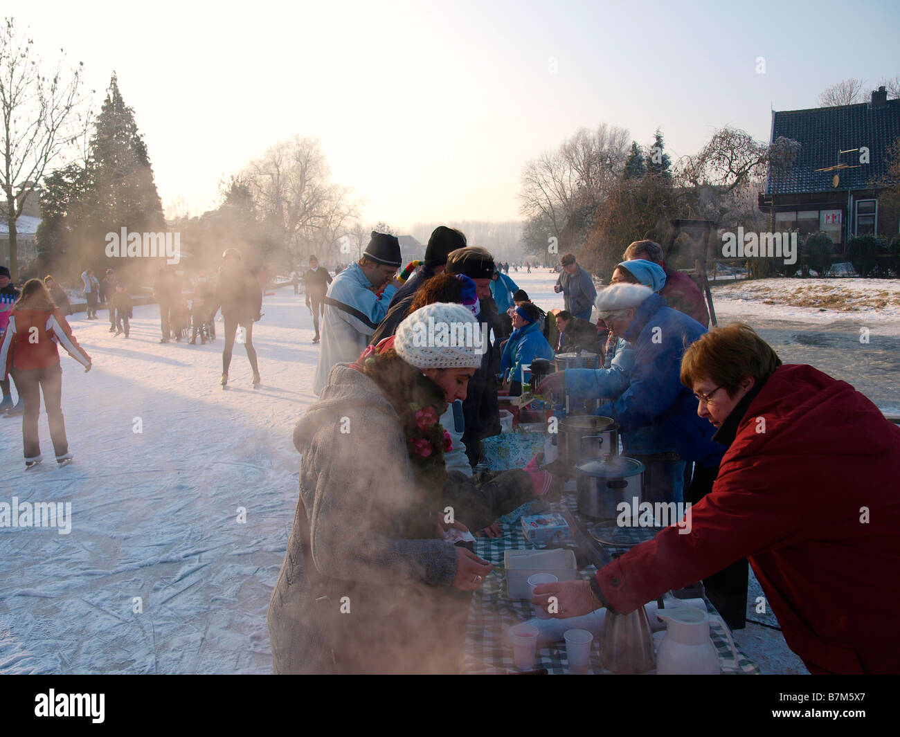 Gente che vende bevande calde e una zuppa ai partecipanti al pattinaggio Molentocht tour utilizzando uno stallo sul ghiaccio Foto Stock