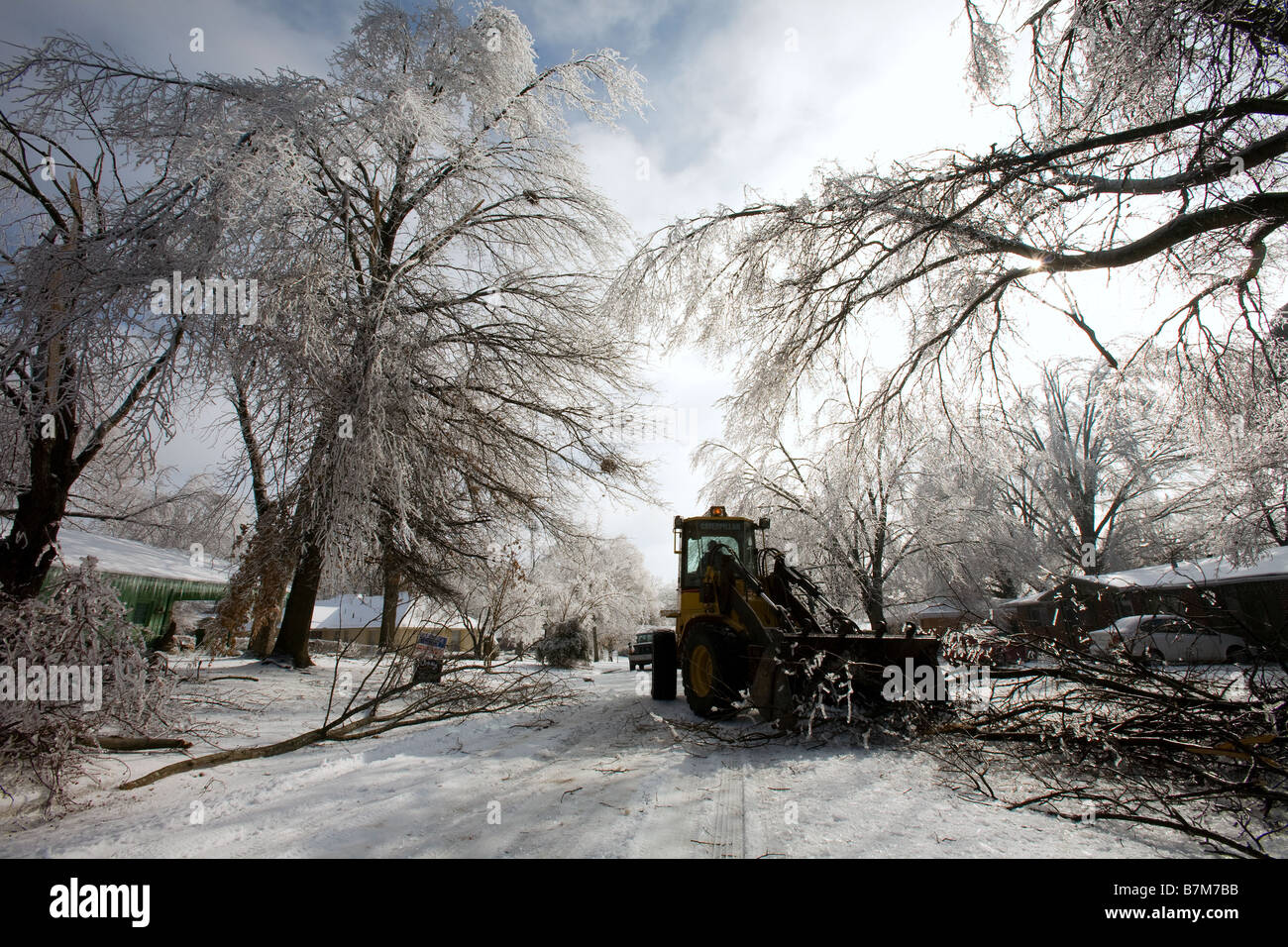 Una estremità anteriore load cancella una strada di arti caduti in seguito ad una tempesta di ghiaccio in un quartiere di Rogers, Arkansas, U.S.A. Foto Stock