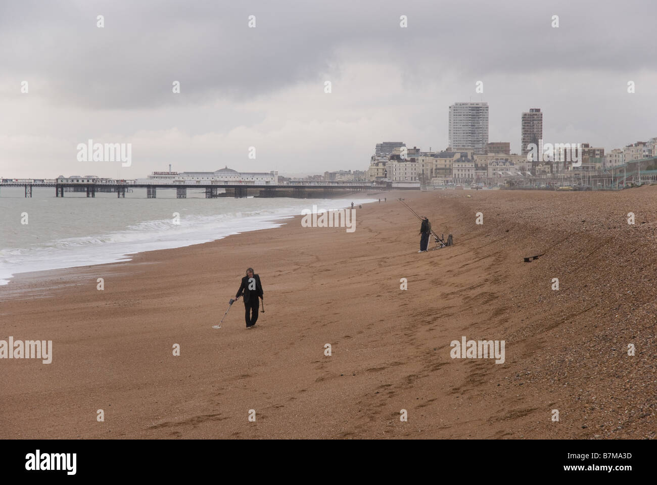 Una persona metallo-rilevare sulla spiaggia di Brighton in Inghilterra in un giorno nuvoloso, dopo una tempesta. Foto Stock