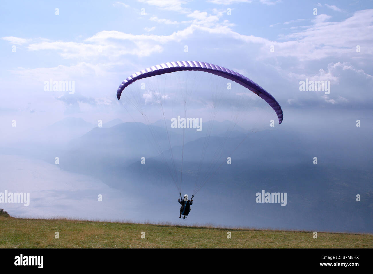 Un parapendio lancia dalla montagna Montebaldo sul Lago di Garda Foto Stock