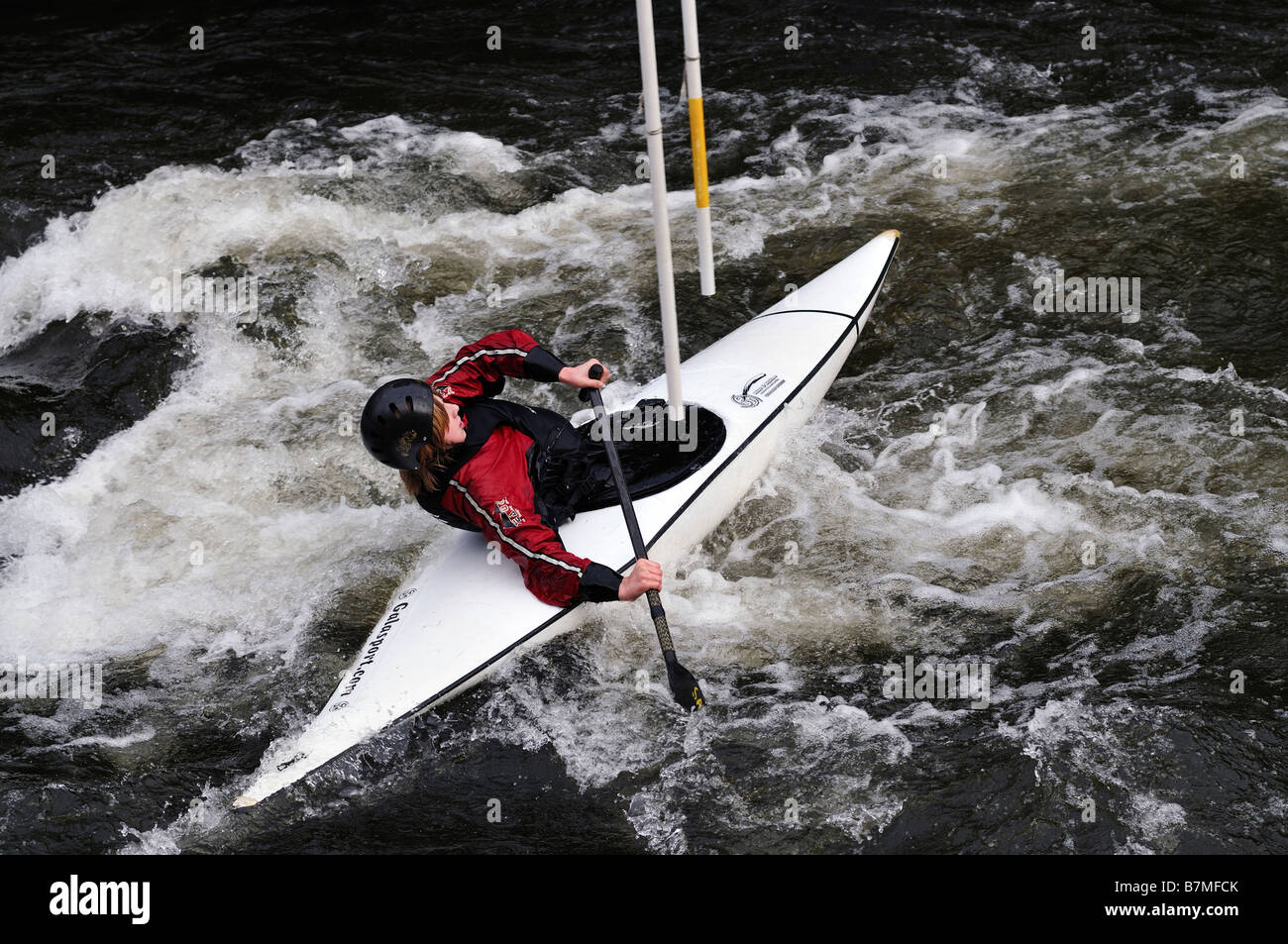 L'uomo la navigazione attraverso i poli in acqua turbolenta in canoa Foto Stock