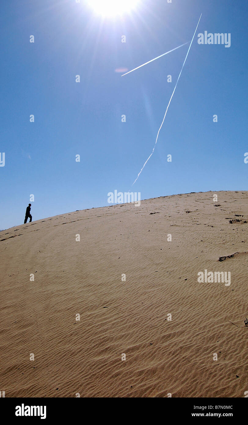 L'uomo vincendo la sfida di salire a piedi a duna di sabbia. Foto Stock