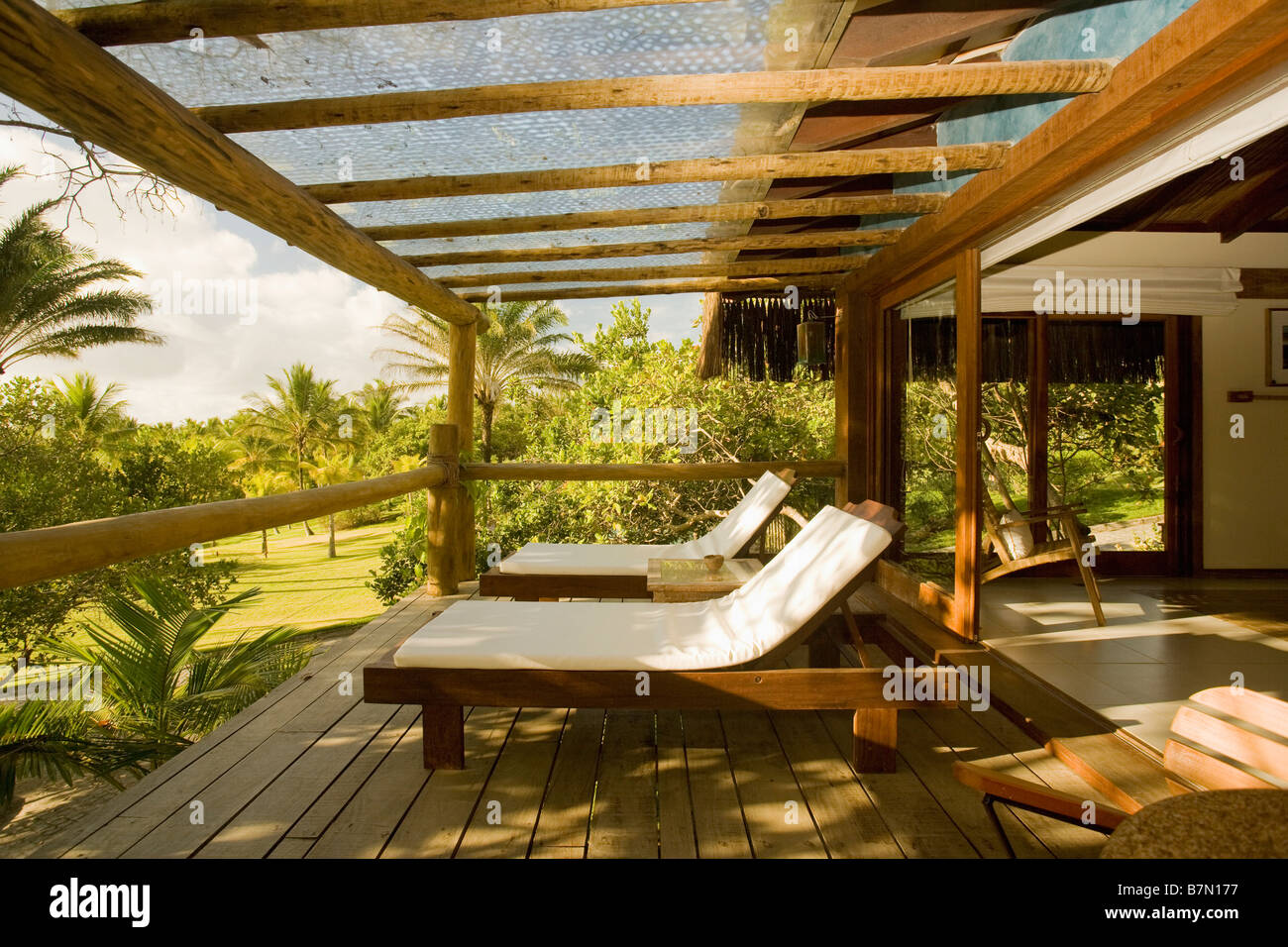 Cuscini bianchi su lettini in legno sulla veranda della moderna casa sulla spiaggia in Brasile Foto Stock