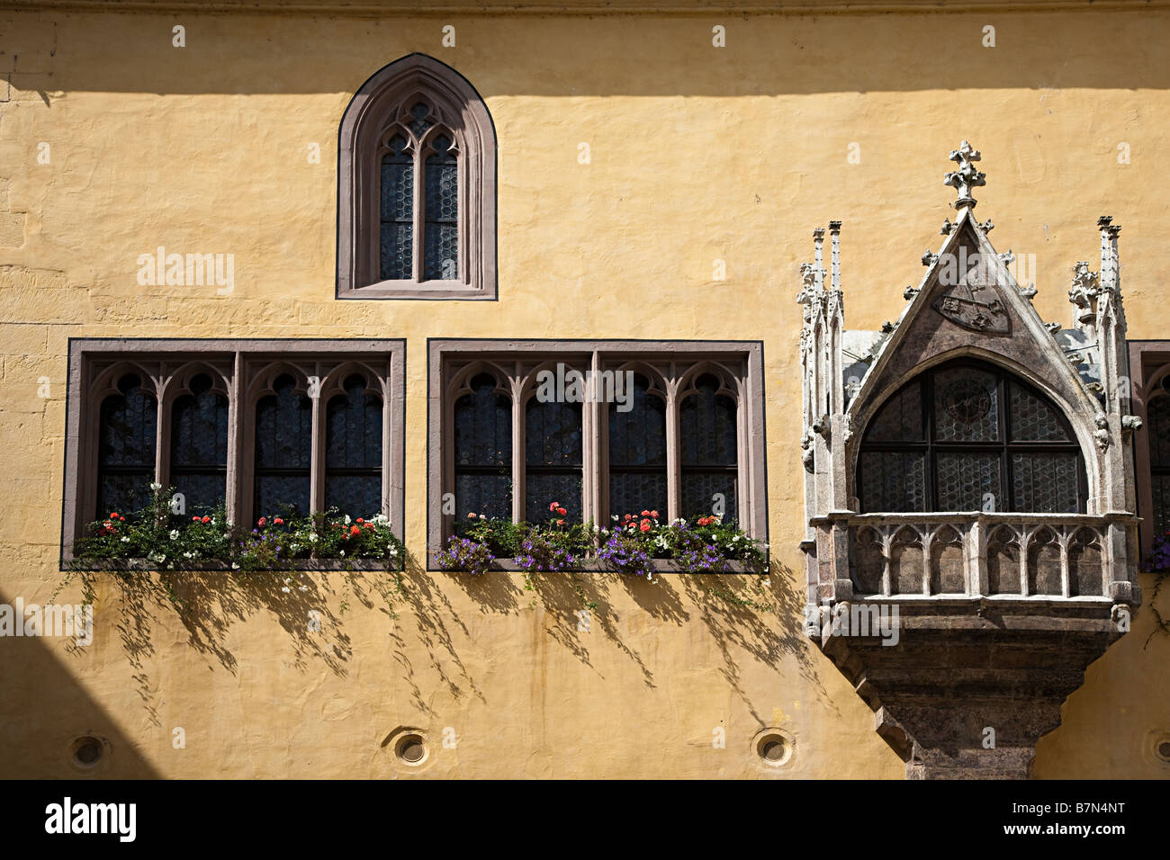 Windows con scatole di finestra sulla vecchia chiesa con balcone che si affaccia su piazza ora il vecchio municipio Regensburg Germania Foto Stock