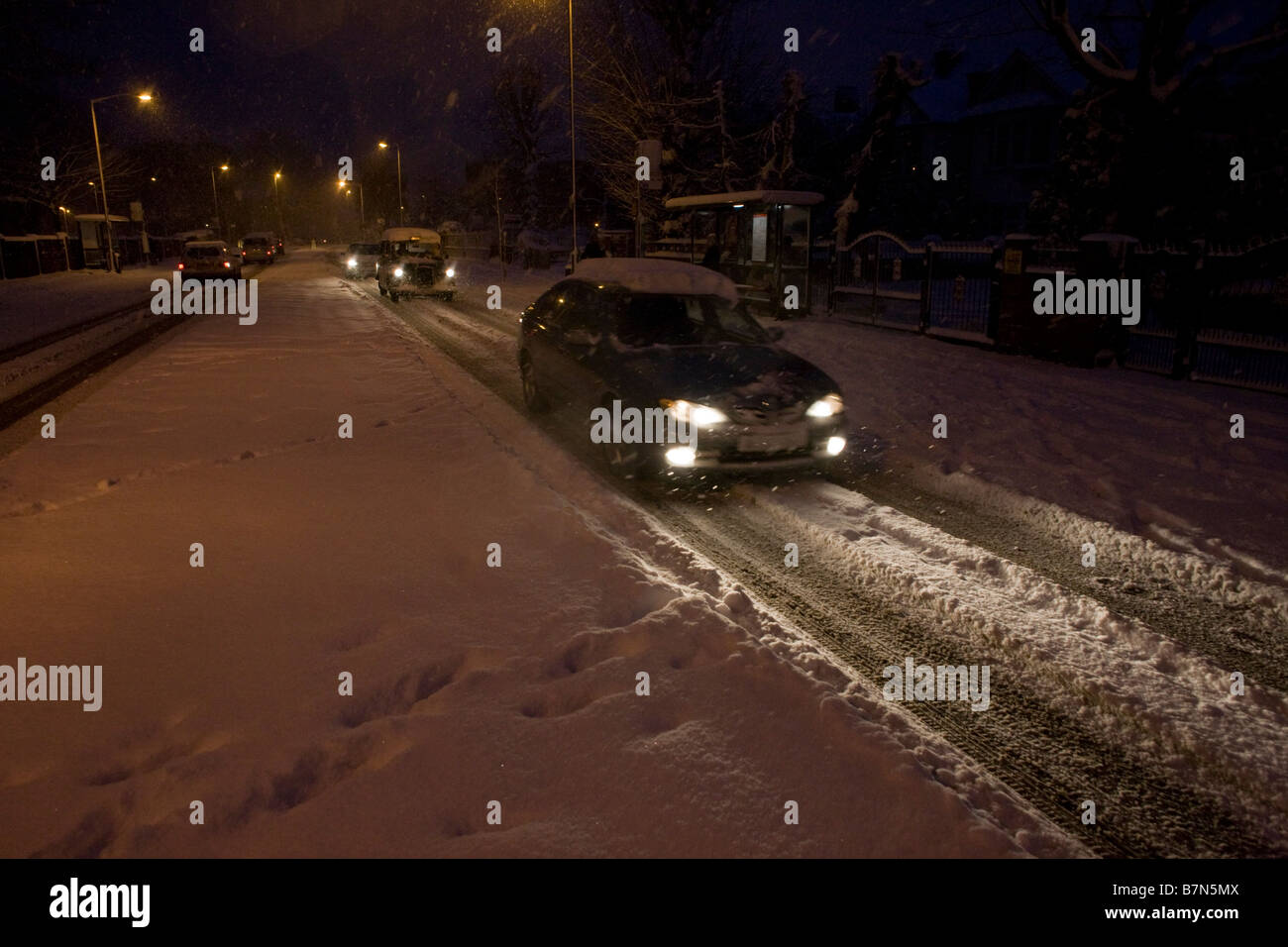 Agli automobilisti di guidare con circospezione lungo Denmark Hill nel sud di Londra dopo aver insolitamente pesanti nevicate Foto Stock