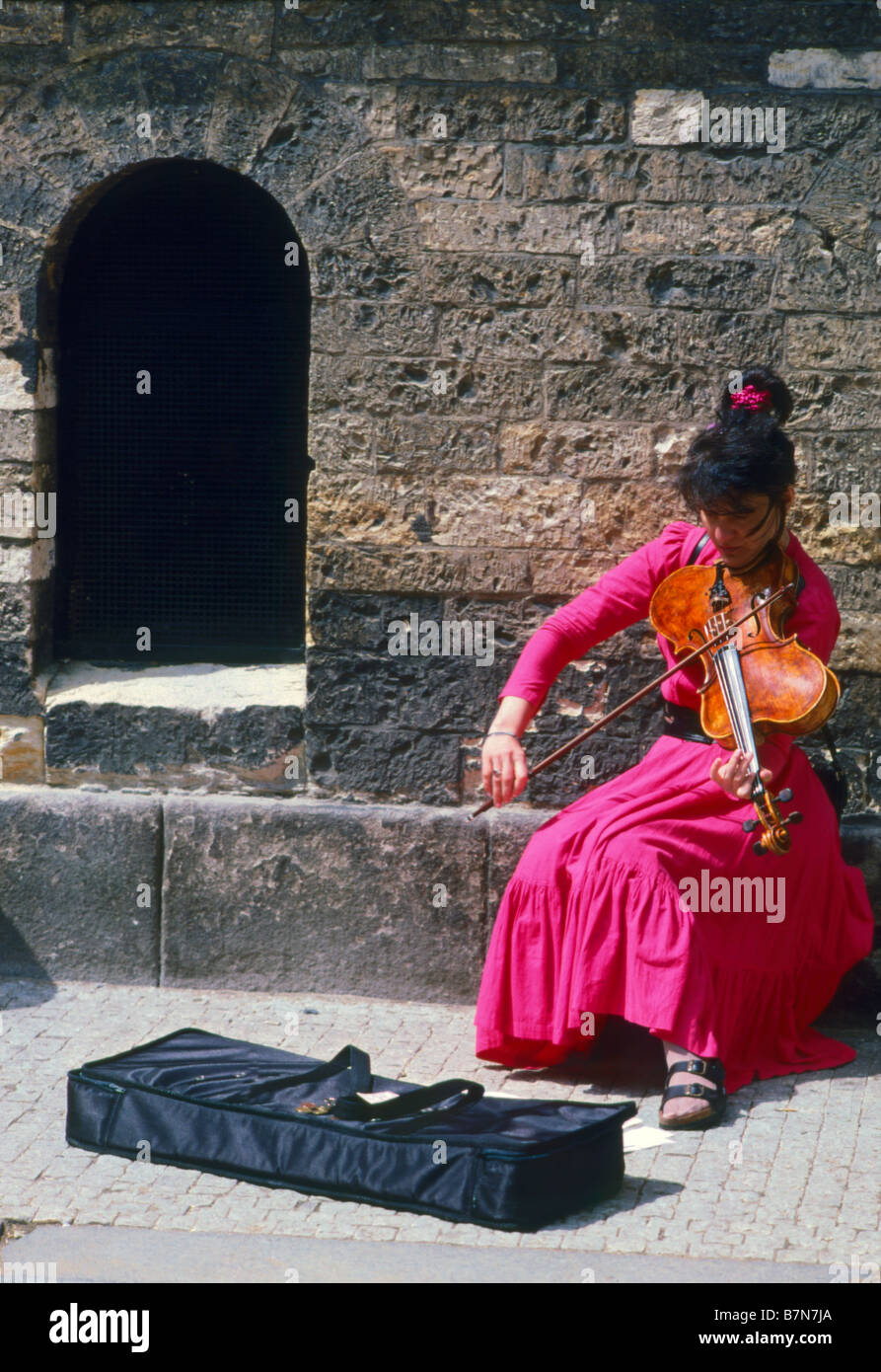 Praga, Repubblica Ceca. Donna che gioca stranamente sagomate violino in strada Foto Stock