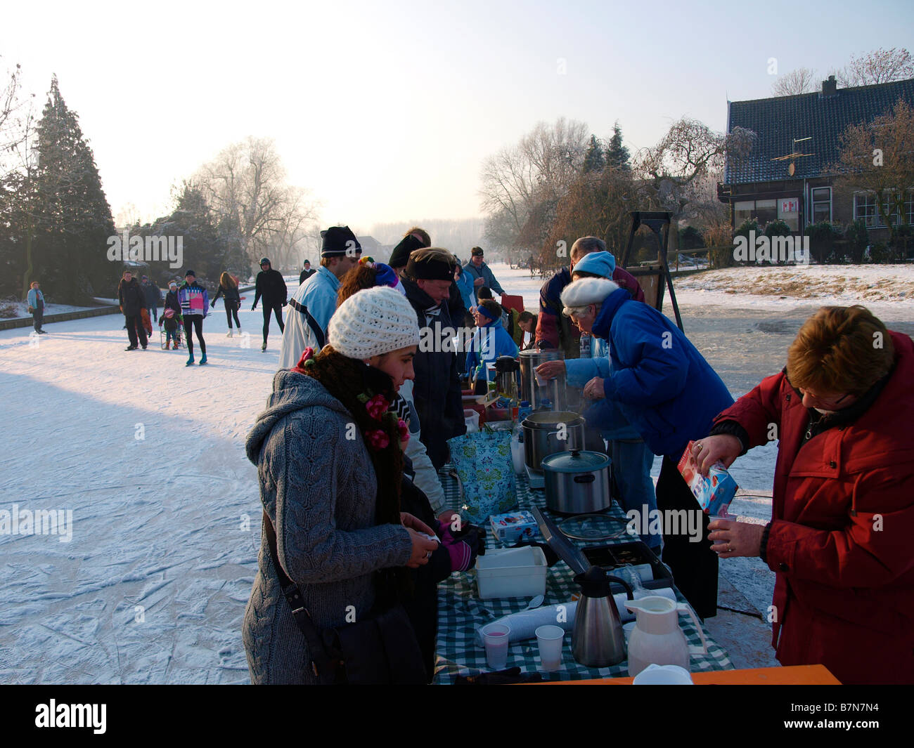 Gente che vende bevande calde e una zuppa di stanchi i pattinatori sul ghiaccio durante il mulino a vento molentocht tour Foto Stock