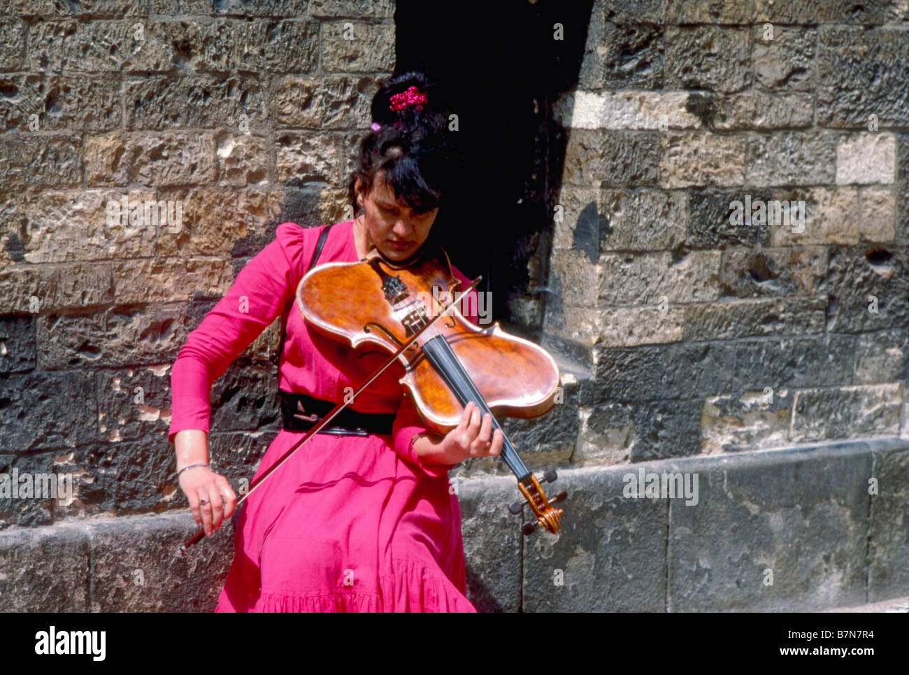 Praga, Repubblica Ceca. Donna che gioca stranamente sagomate violino in strada Foto Stock