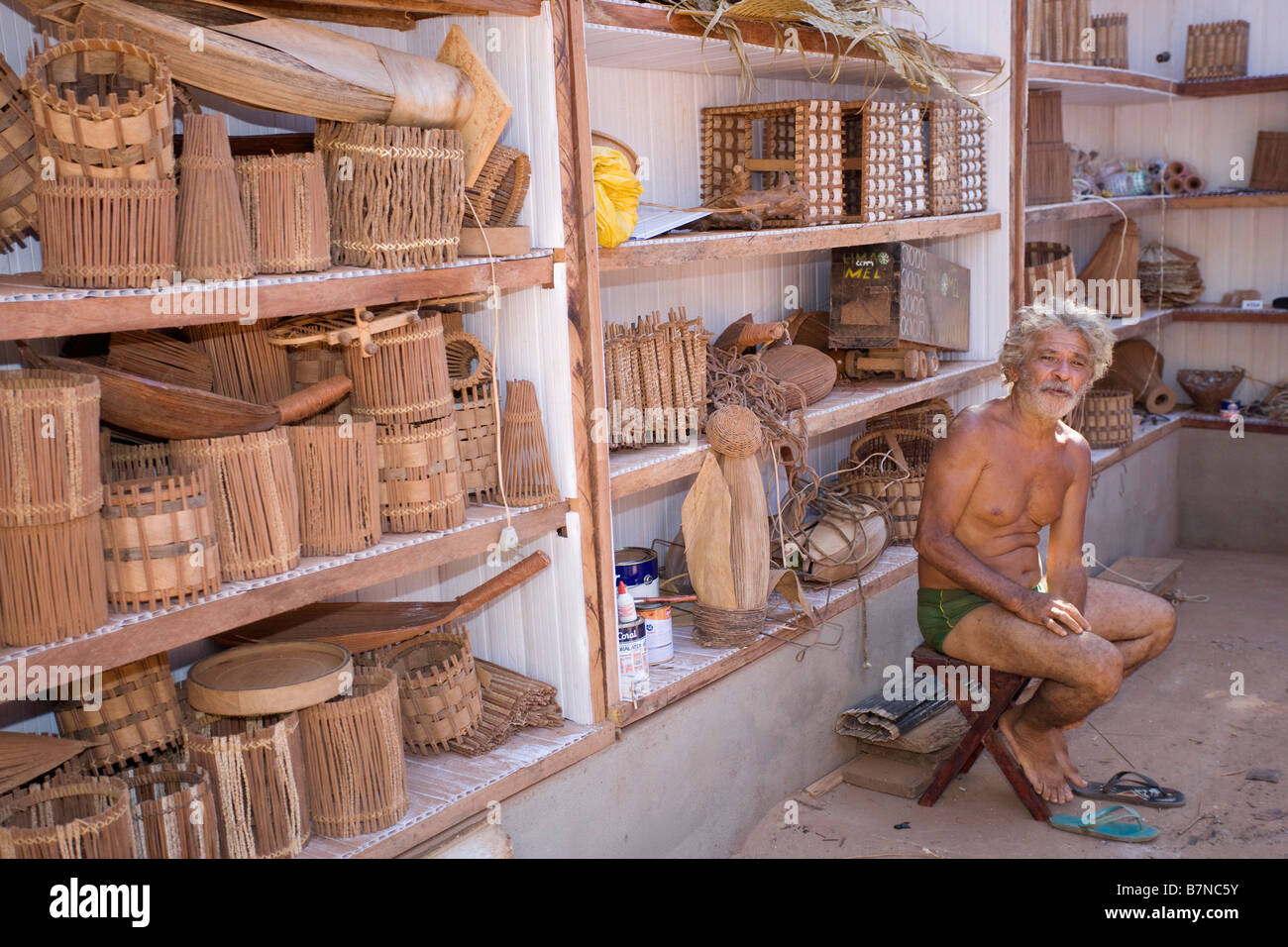 Uomo con cestello brasiliano lavoro negozio di souvenir in vendita per i turisti in Brasile Foto Stock