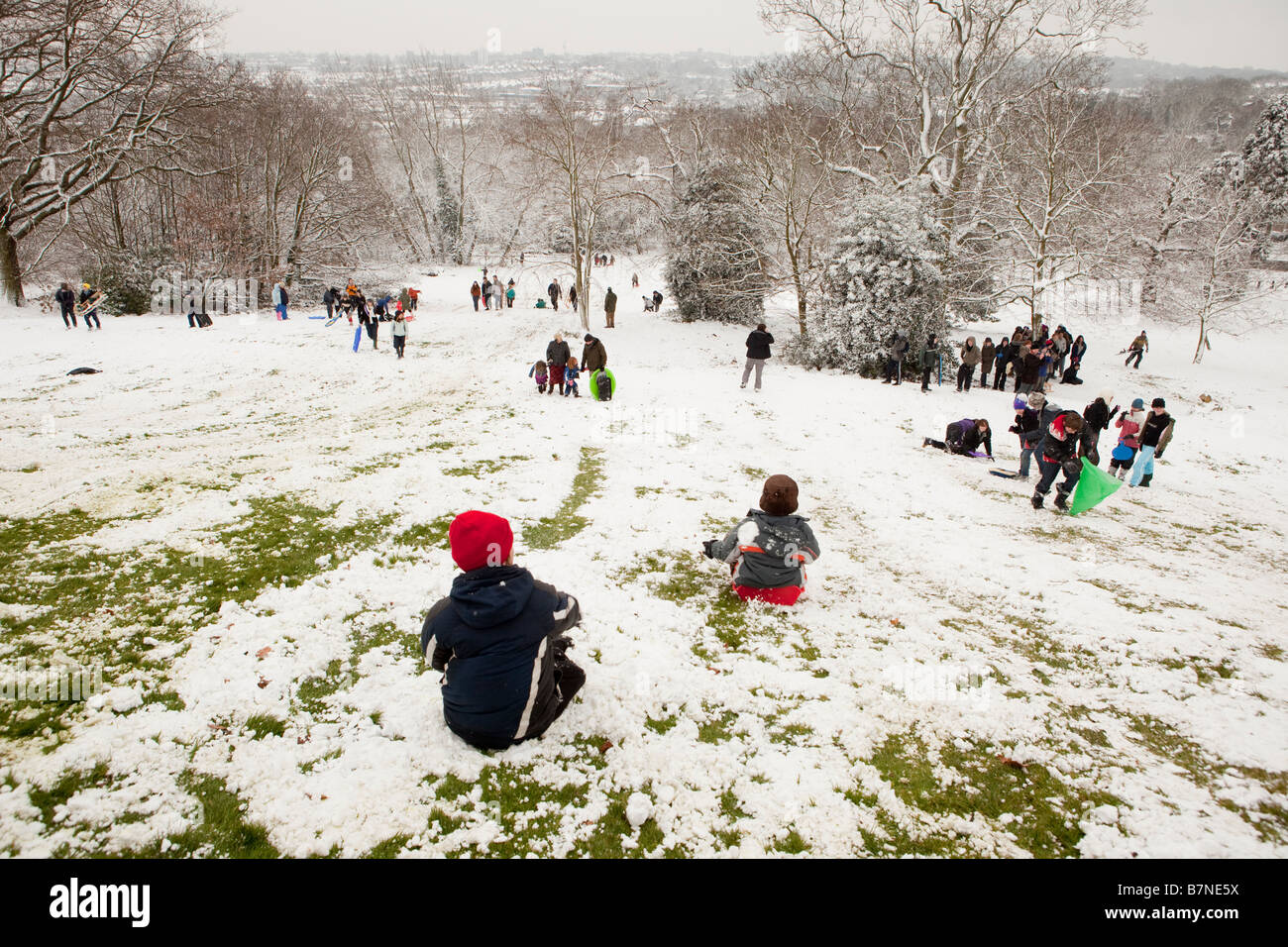 Gli adolescenti e i bambini giocano sulle nuove nevicate a Alexandra Pallace nel nord di Londra dopo le scuole hanno chiuso Foto Stock