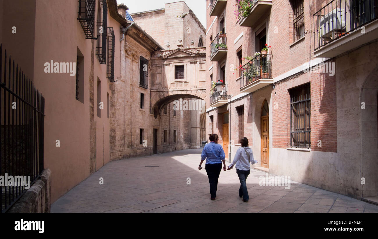 2 persone passeggiando attraverso un medievale back street vicino a La Catedral de Valencia Spagna Foto Stock