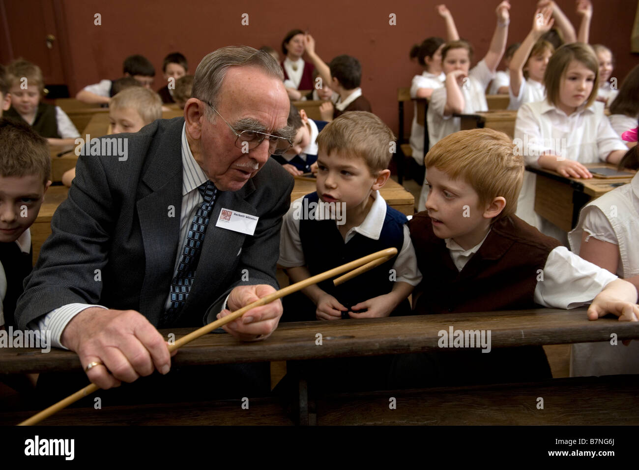 Bambini esperienza di vita in una scuola vittoriana durante una visita a Queen Street Scuola Barton upon Humber Lincolnshire Un anziano m Foto Stock