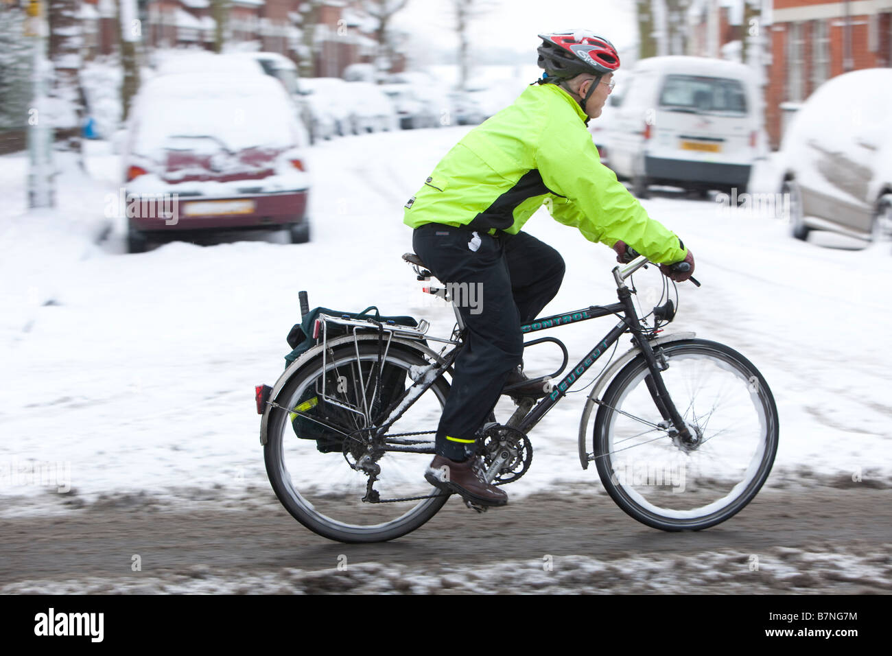 Escursioni in bicicletta a lavorare su una strada principale che è stato gritted nel nord di Londra dopo la più pesante la caduta di neve a Londra per 18 anni Foto Stock