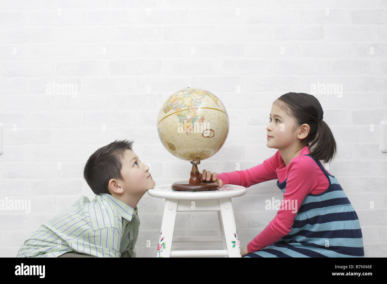 Bambini e un globo terrestre Foto Stock