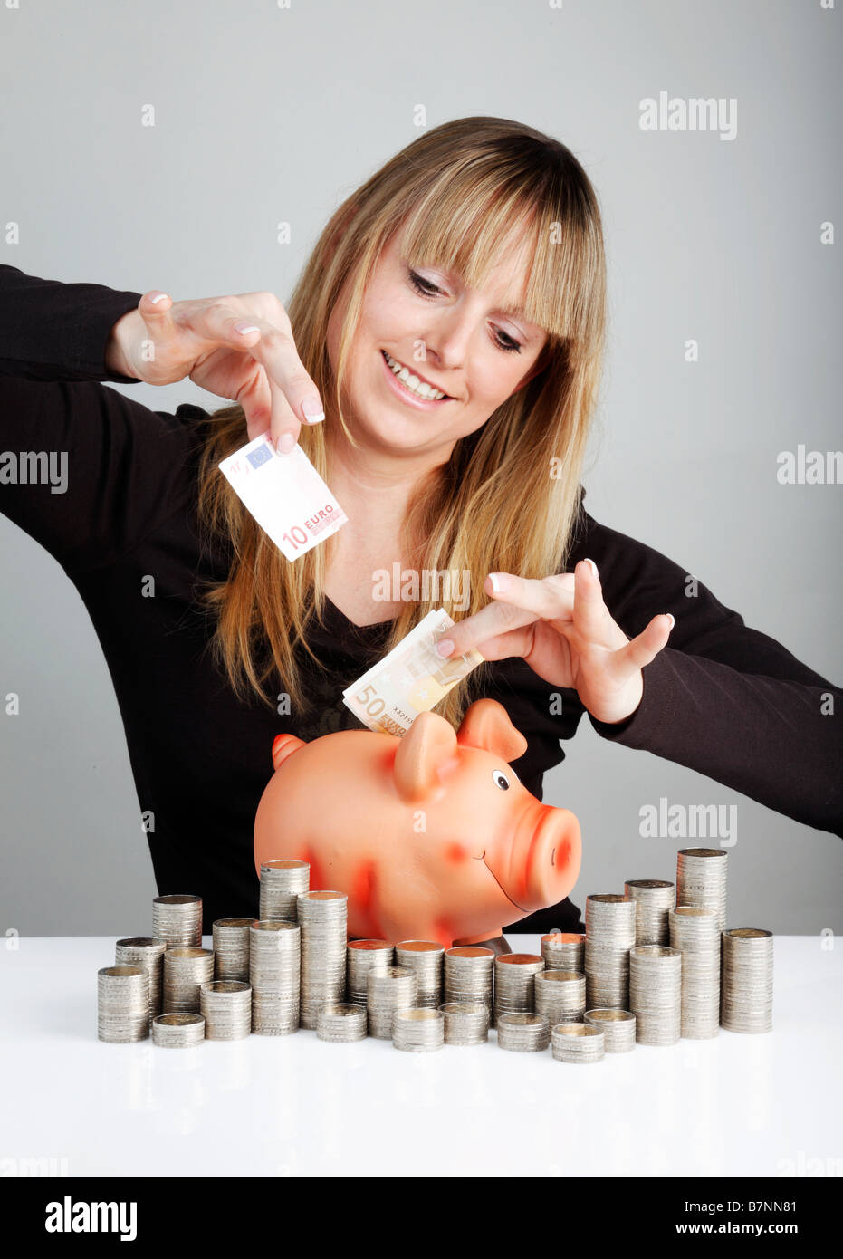 Giovane donna con un piggybank Foto Stock