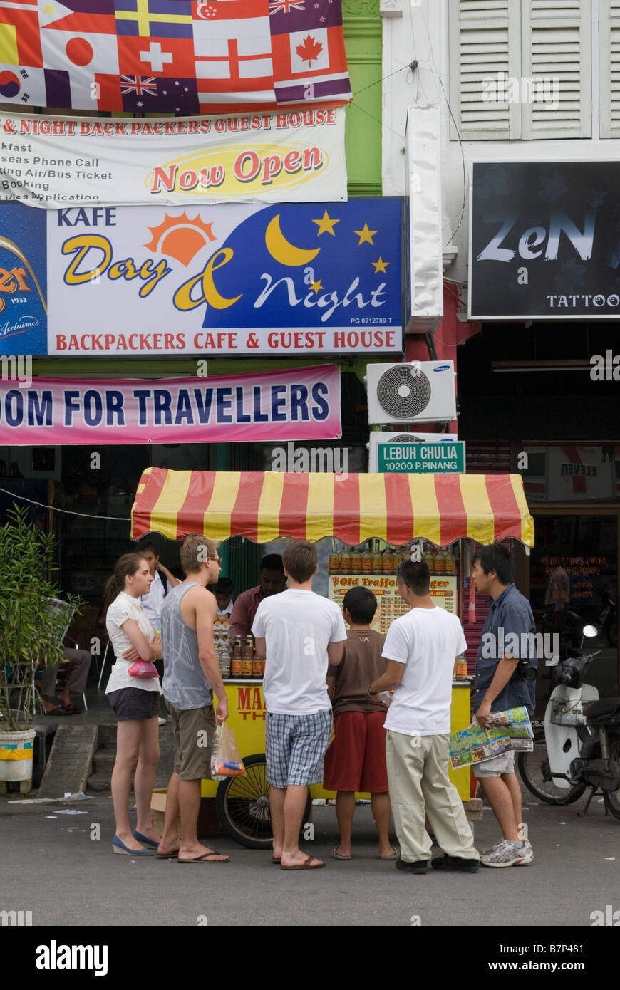 I viaggiatori in attesa di comprare il cibo da un cavalletto di Penang, Malaysia Foto Stock