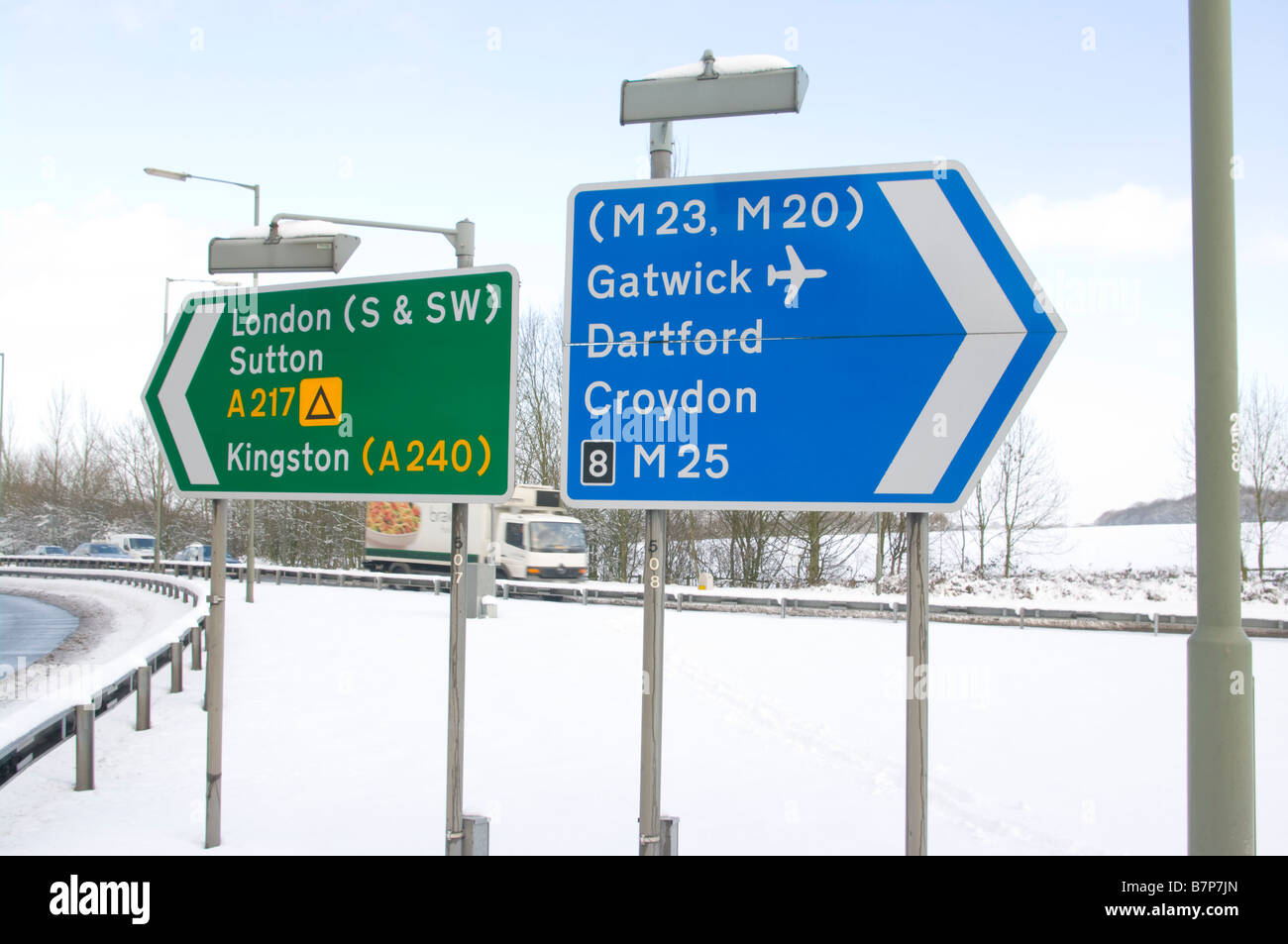 Nel regno unito il traffico su strada segno segni cartelli nella neve al Junction 8 M25 A217 Foto Stock