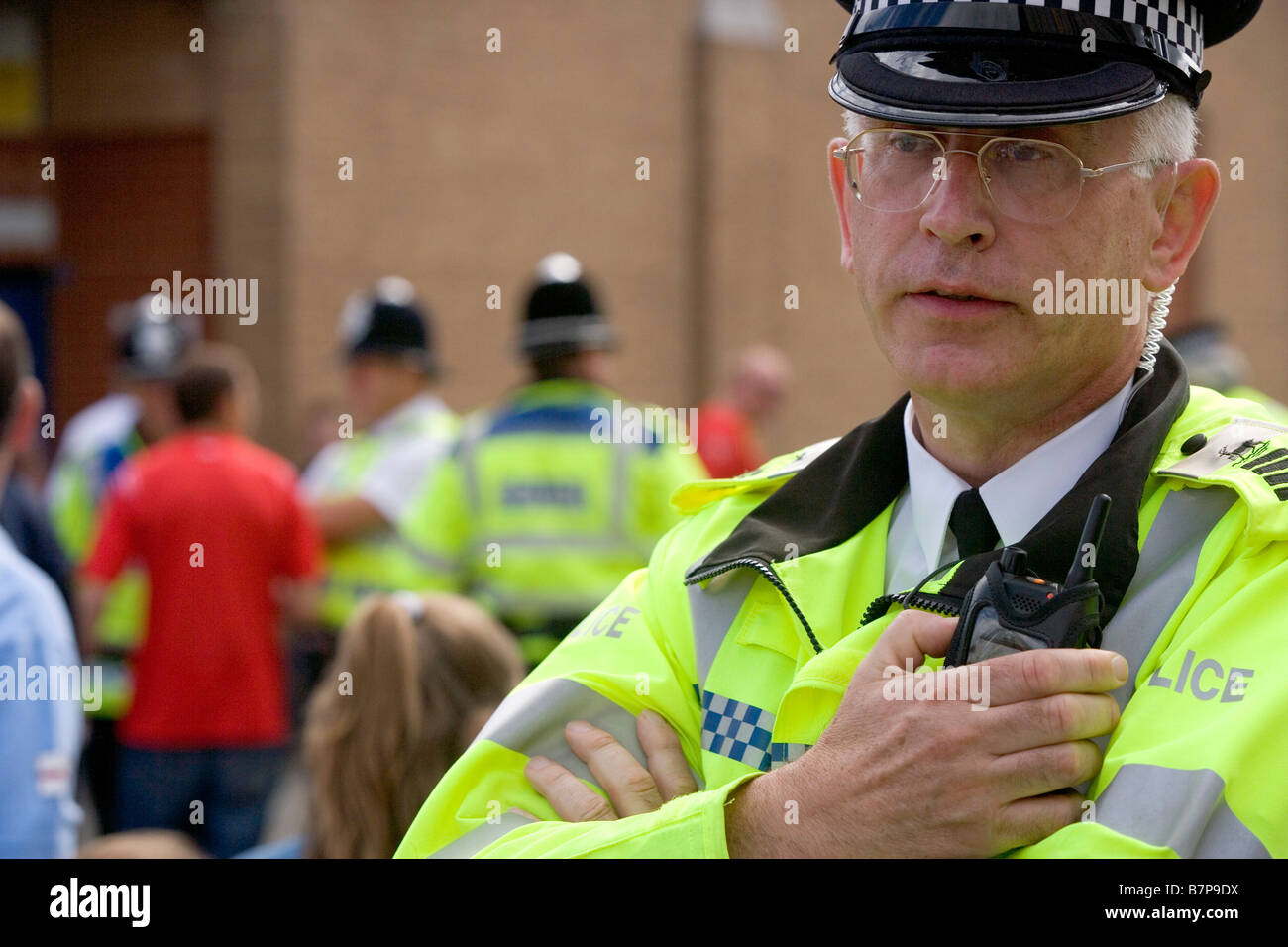 Il comandante del Hertfordshire Special Constabulary colloqui sulla sua radio al di fuori di Watford Stadium prima di una partita Foto Stock