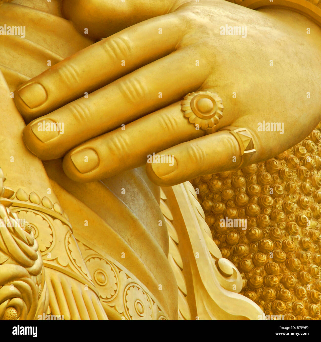 La mano di un dorato statua del Buddha Foto Stock