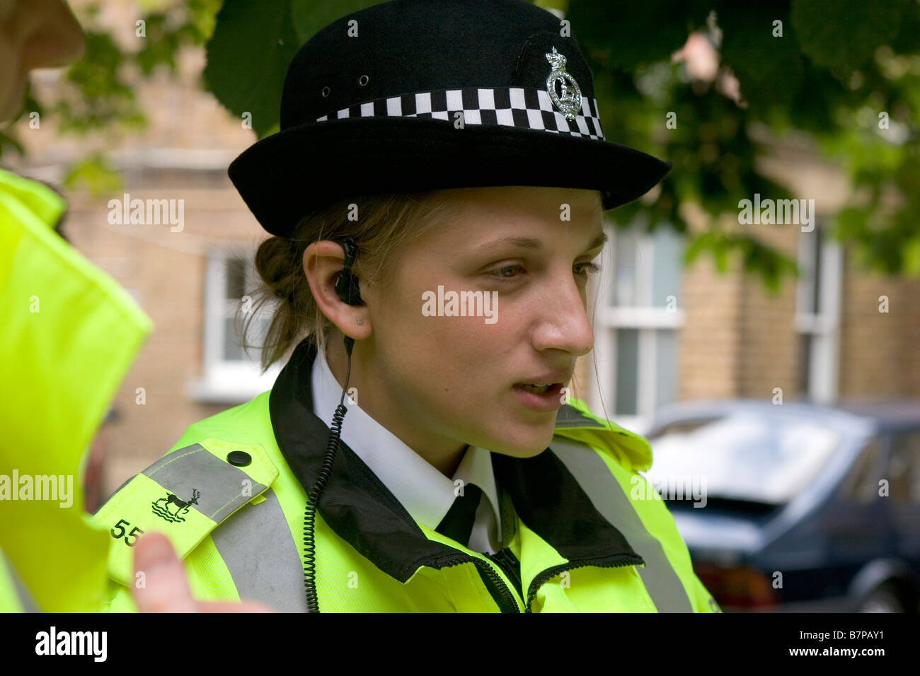 Una donna Special Constable colloqui con i colleghi dopo una sessione di briefing Foto Stock