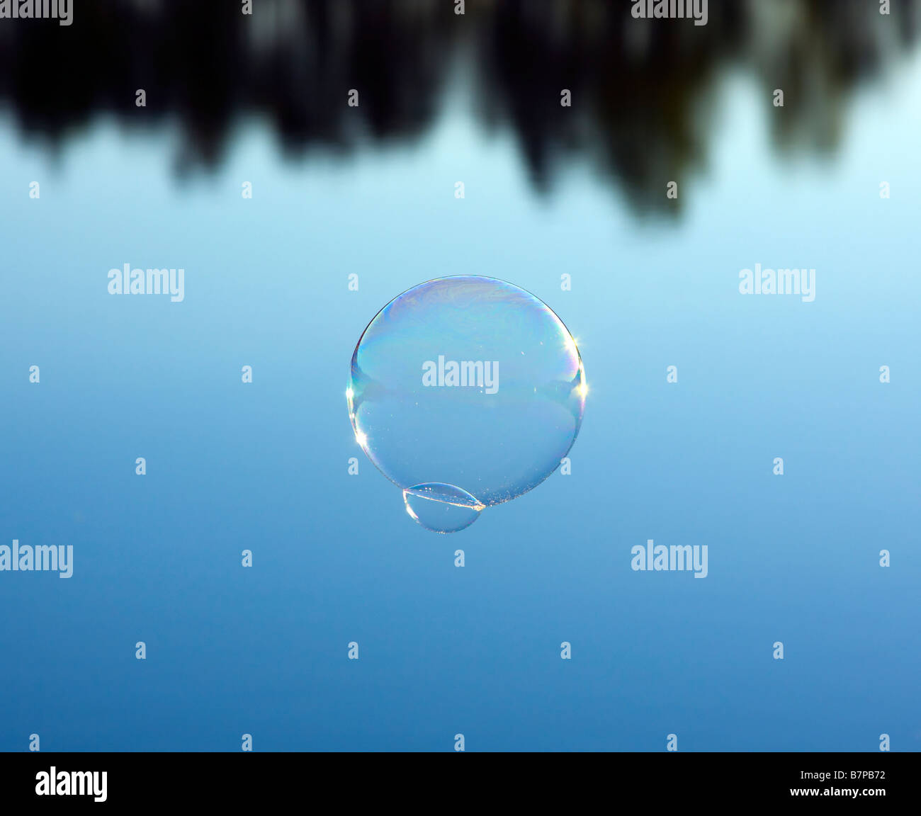 Bubble vola sopra l'acqua blu Foto Stock
