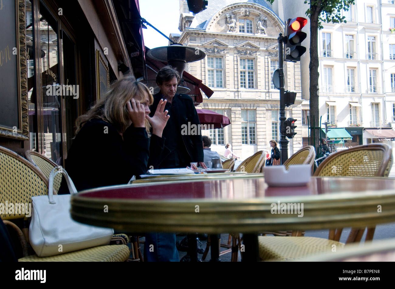 una donna sta avendo il caffè seduto su un tavolo esterno In un bar nel centro di Parigi Foto Stock