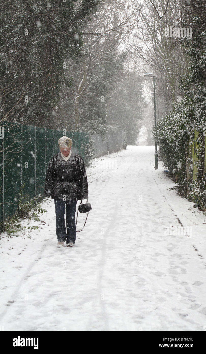 Femmina solitario a piedi su una coperta di neve sul sentiero. Foto Stock
