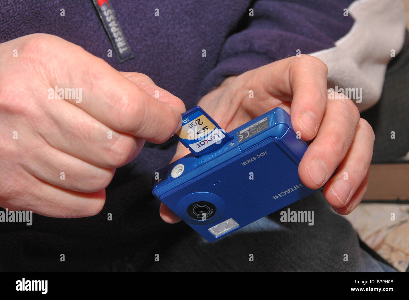 Scheda di memoria che viene inserita in un bambino fotocamera digitale. Foto Stock