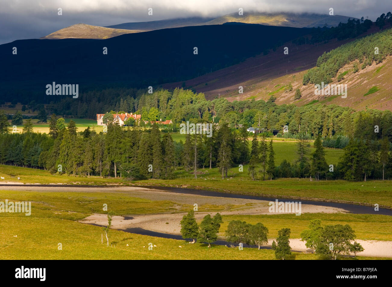 Il fiume Dee serpeggianti passato Mar Lodge, vicino a Braemar, con le colline di Ben Macdui e Derry Cairngorm nei Cairngorms dietro Foto Stock
