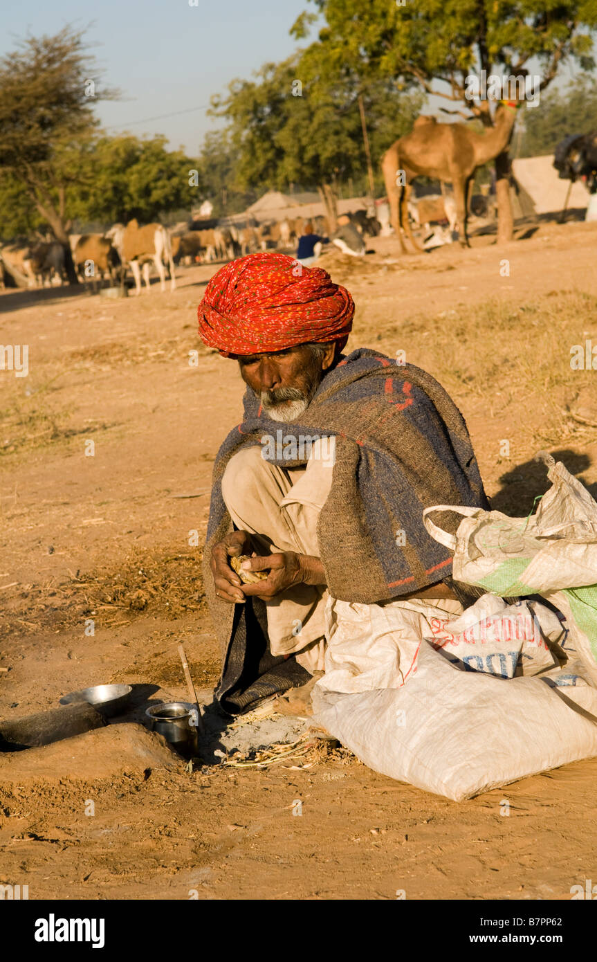 Un vecchio uomo di Rajasthani si prepara per la lunga giornata di Nagaur fiera del bestiame nel Rajasthan, India. Foto Stock