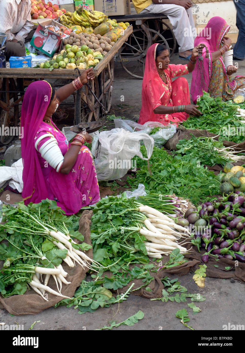 Le donne indiane in abito tradizionale vendita di verdure al mercato nelle stradine della città vecchia di jaisalmer Foto Stock
