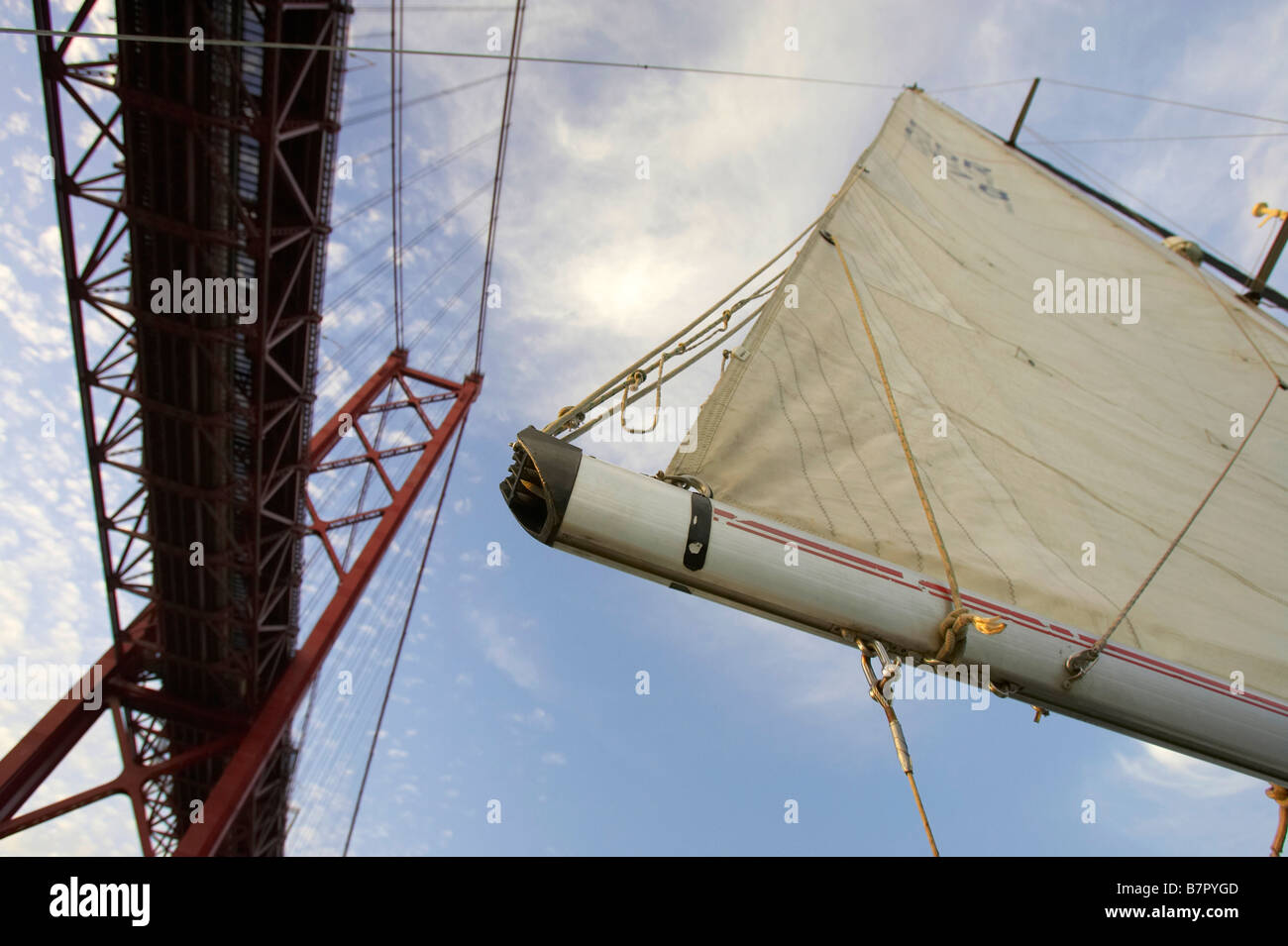 Imbarcazione a vela in fiume Tago (fiume Tejo) vicino al XXV Aprile del ponte, a Lisbona. Foto Stock
