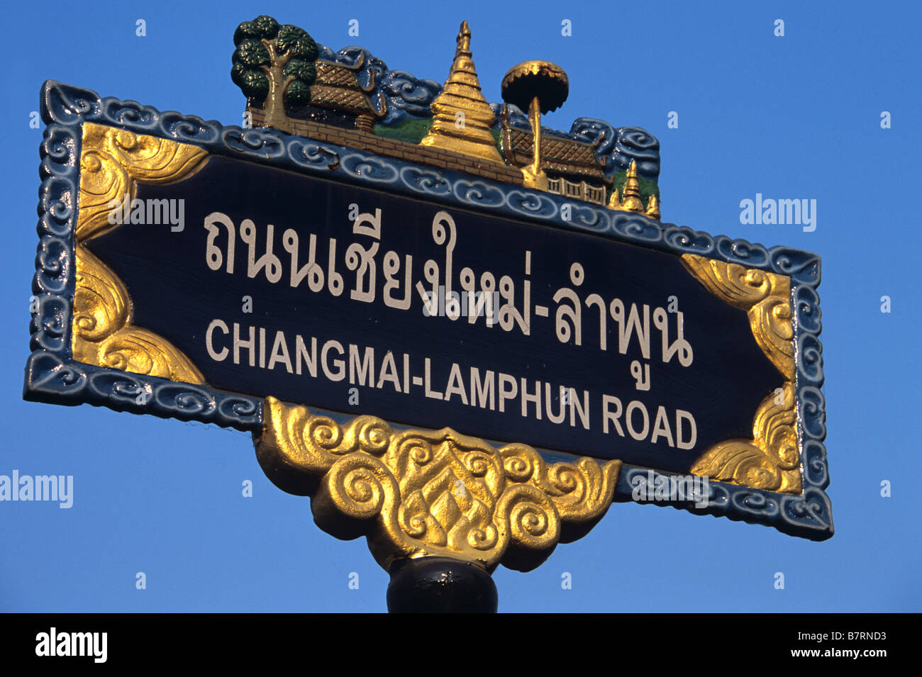 Bilingual strada segno, Chiang Mai - Lumphun Road, Chiang Mai, scritta in alfabeto tailandese & Inglese Script romano, Thailandia del Nord Foto Stock