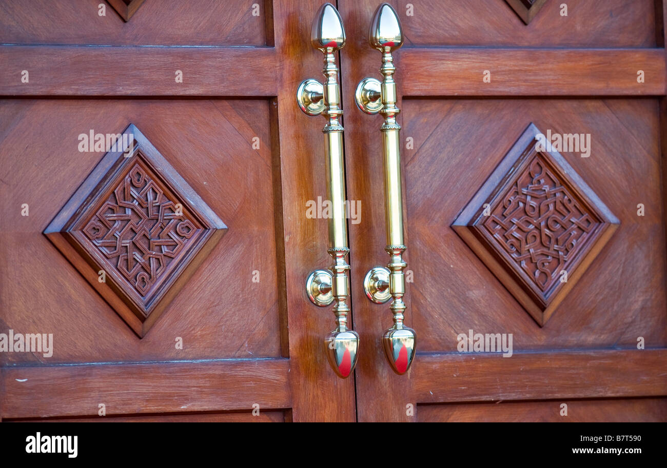 Ornati in legno porta esterna e maniglie in ottone, Dawoodi Bohra moschea, Northolt, London REGNO UNITO Foto Stock