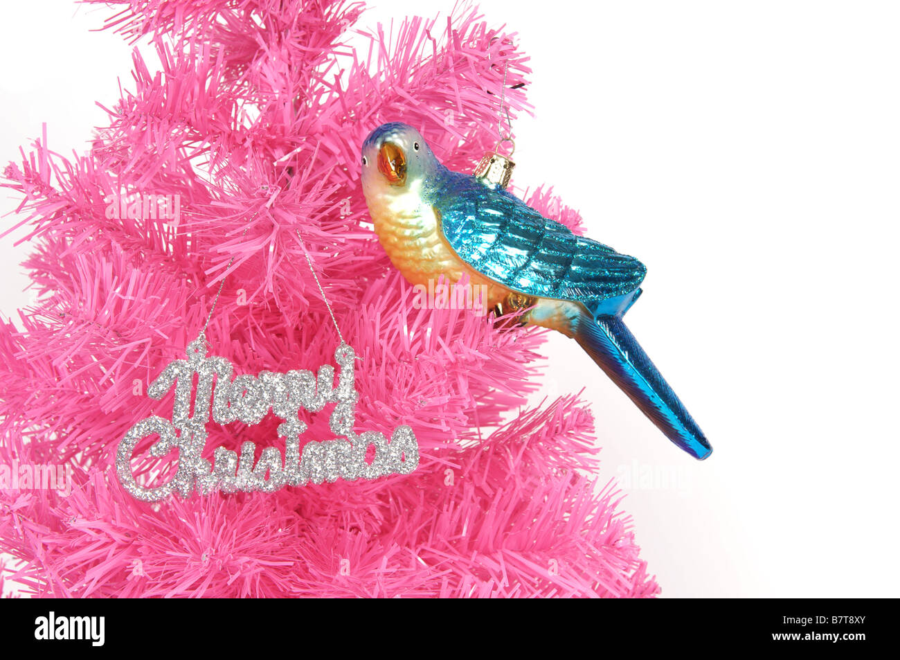 Tacky albero di Natale rosa di plastica con uccello bauble e allegro segno di Natale Foto Stock