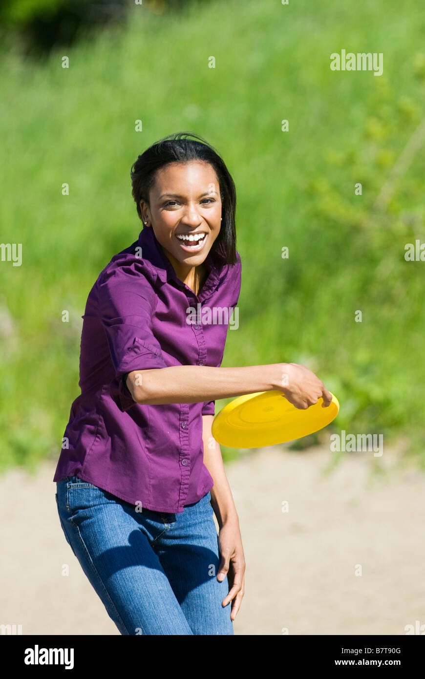 Donna gettando un flying disc Foto Stock