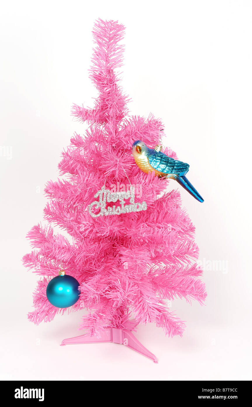 Plastica rosa albero di Natale con shiny ninnolo, bird decorazione e buon Natale segno. Foto Stock