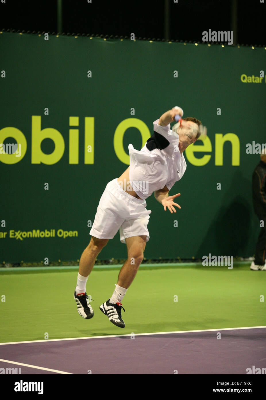 Andy Murray serve il suo volto parzialmente oscurata dalla sfocatura del suo racquet durante il suo raddoppia corrispondono al Qatar Open 2009 Foto Stock