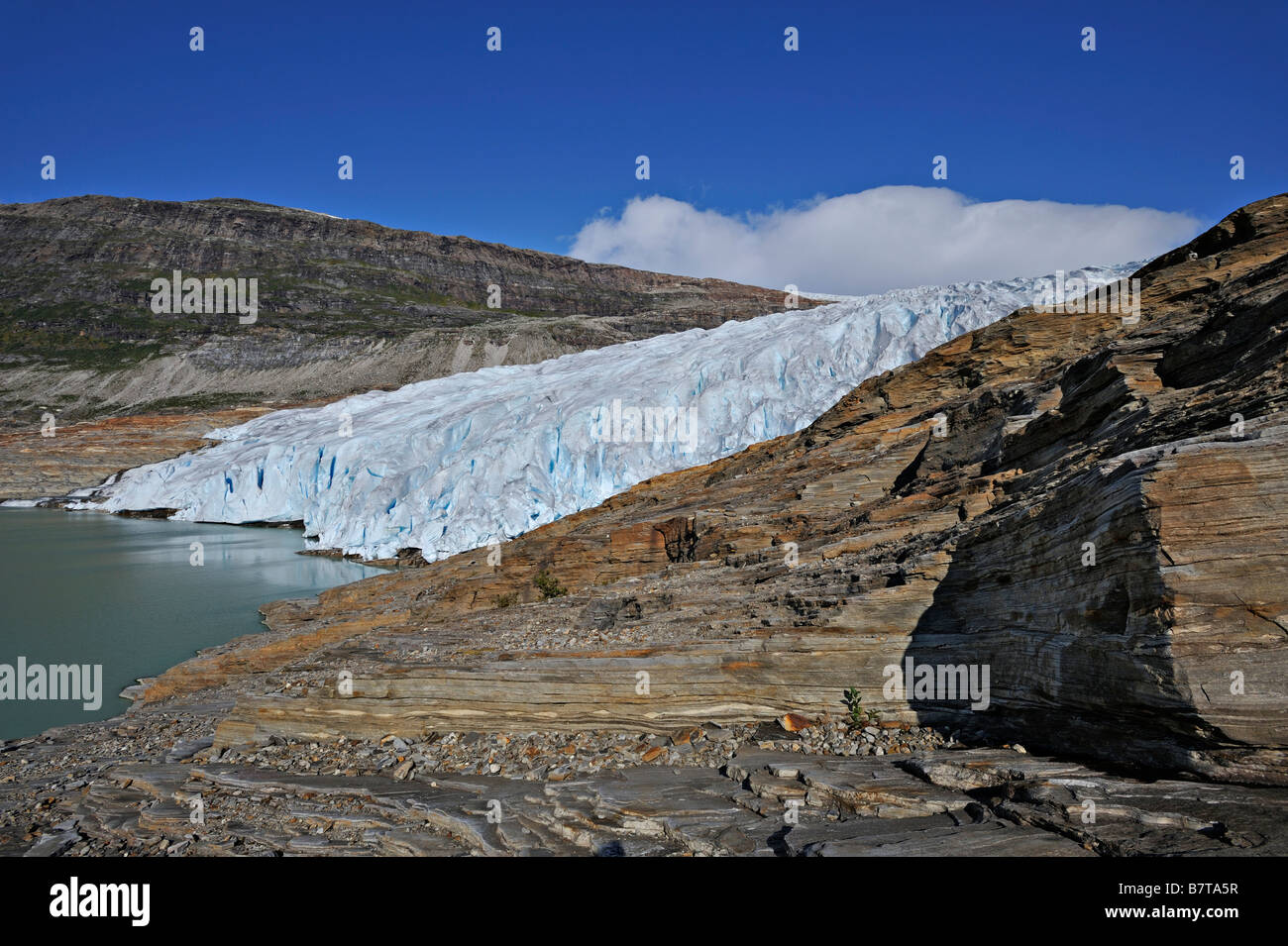 Linguetta sul ghiacciaio o muso dalla Svartisen tappo di ghiaccio cade in un lago di acqua di disgelo Osterdalen Norvegia Foto Stock