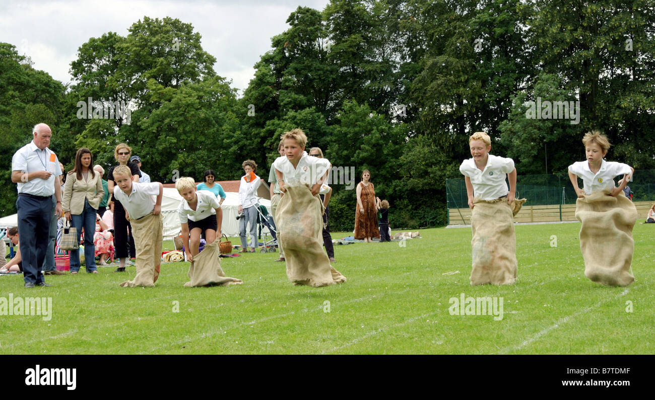 Bambini racing in la corsa con i sacchi, scuola primaria giornata di sport, REGNO UNITO Foto Stock