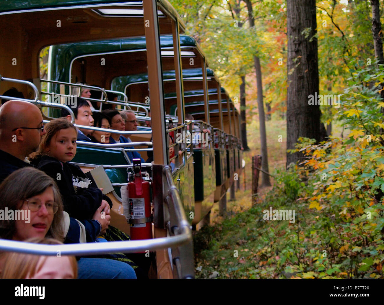 Passeggeri viaggia il Bronx Zoo monorotaia attraverso una zona boscosa. Foto Stock