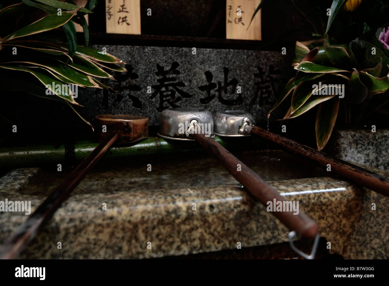 Siviere di colata di acqua sulle mani e viso sono collocati su una fontana all'entrata di un tempio di Kyoto, Giappone. Foto Stock