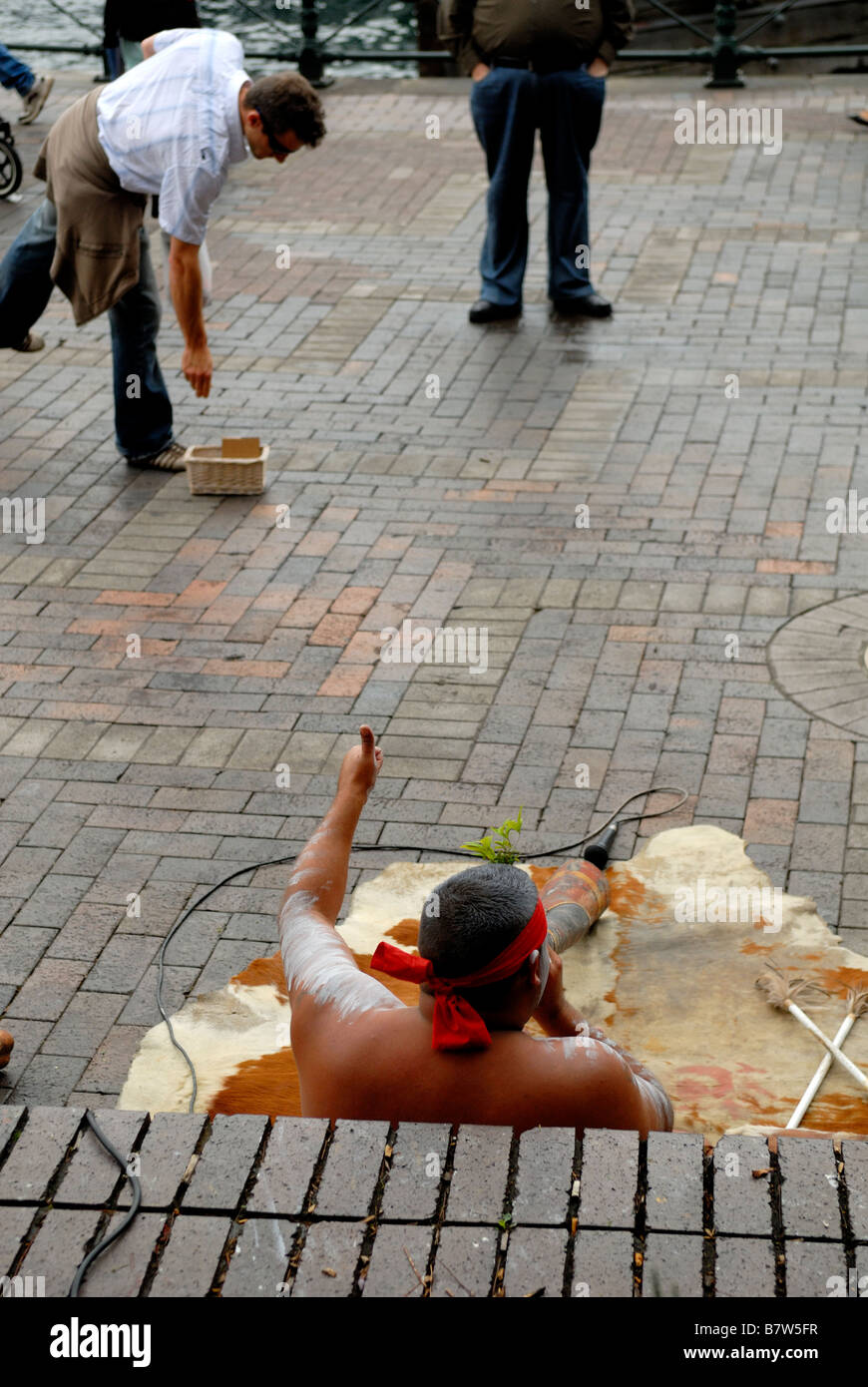 Suonatore ambulante Aborigeno di dare "Thumbs up' alla persona che immetta denaro in hat. La Circular Quay, Sydney, Australia Foto Stock